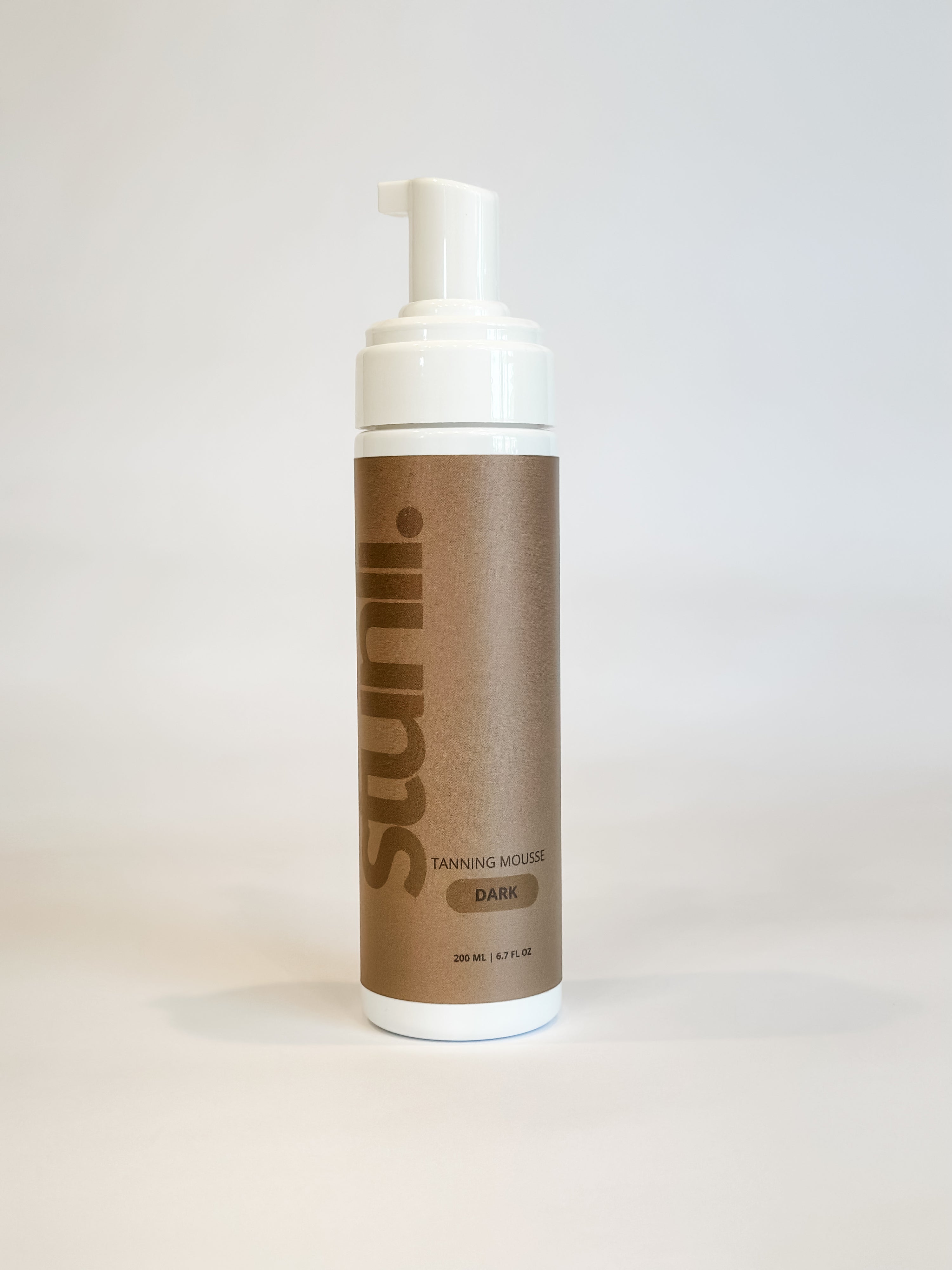 A bottle of tanning mousse on a white background.