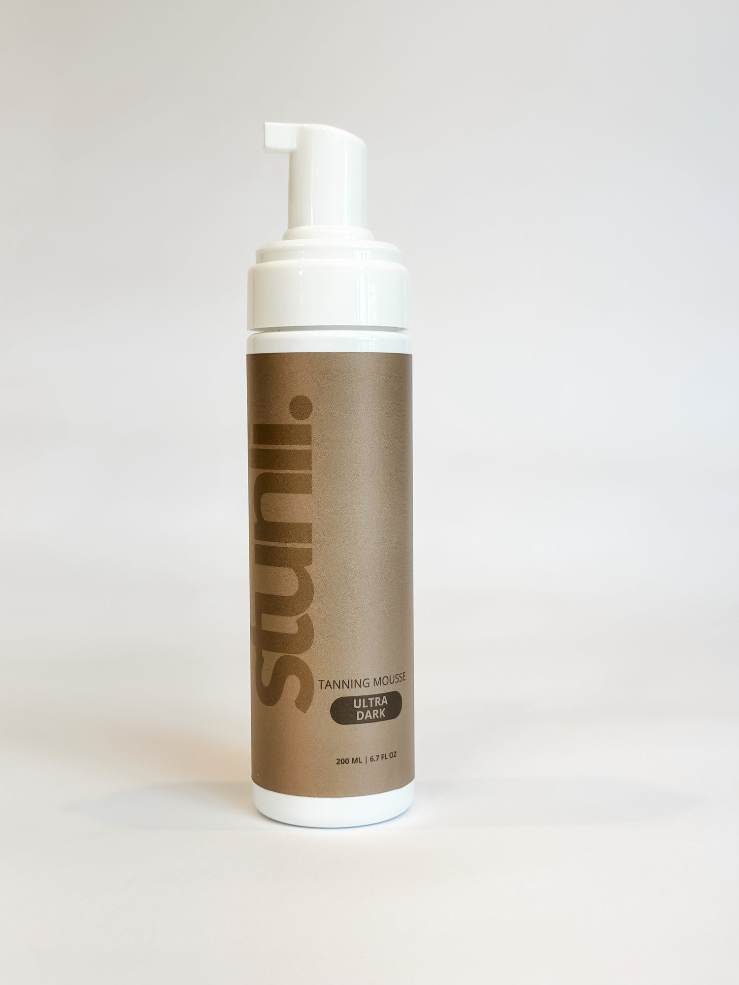 A bottle of Stunli brand tanning mousse in shade Ultra Dark in front of a white background.