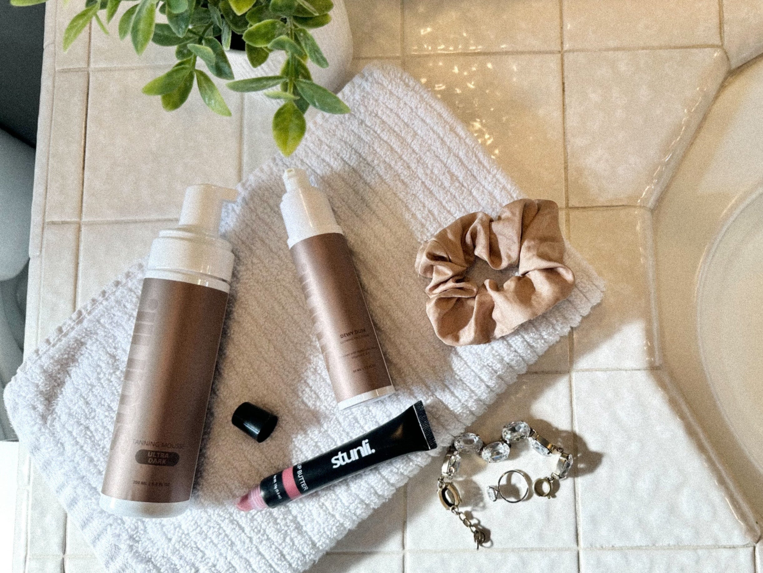 Cosmetic products on a towel next to a sink