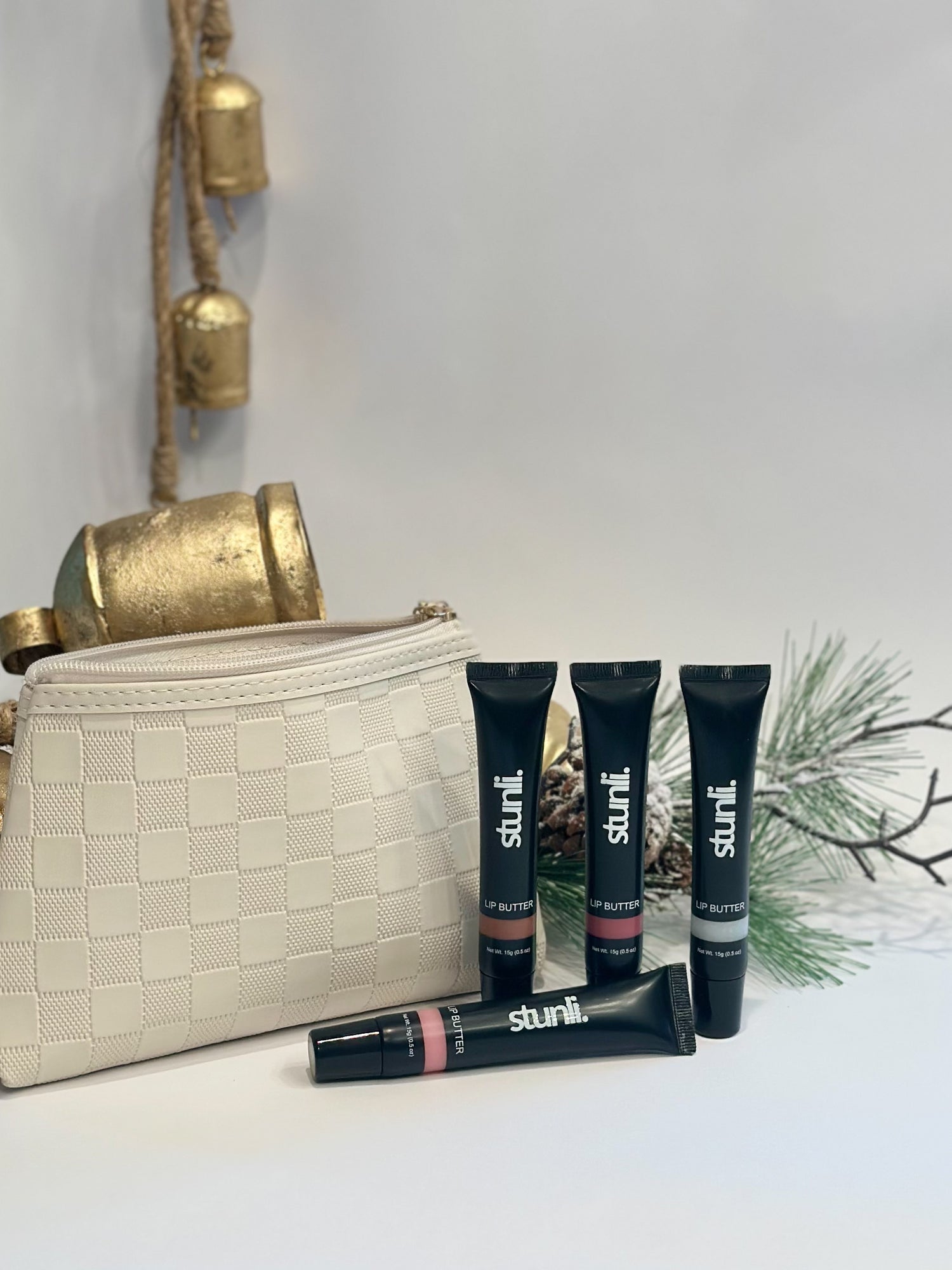 Stunli makeup products with a beige handbag on a light background