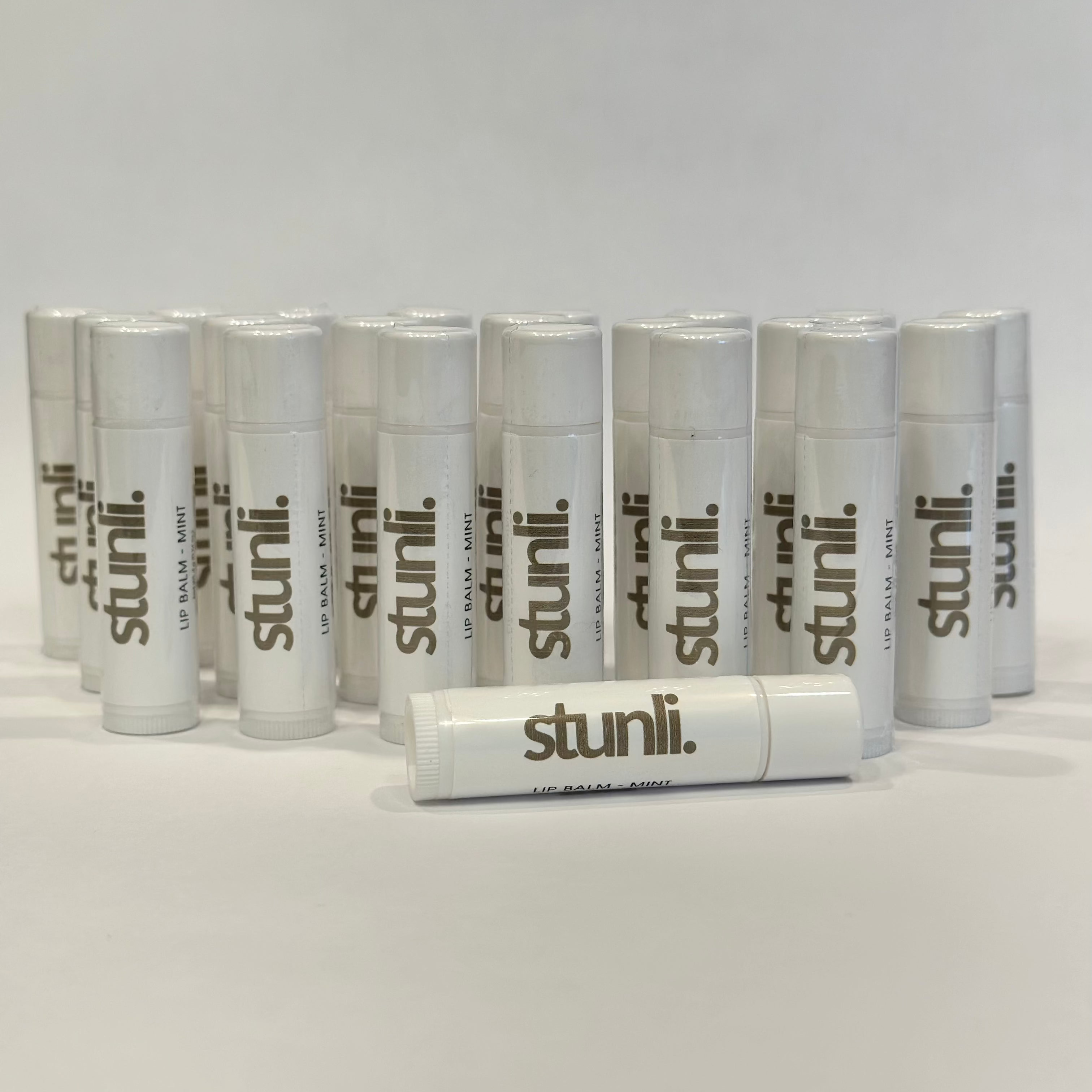 Multiple stunli lip balms arranged on a light gray background