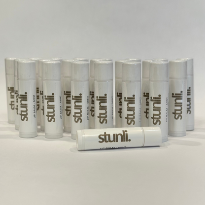 Multiple stunli lip balms arranged on a light gray background